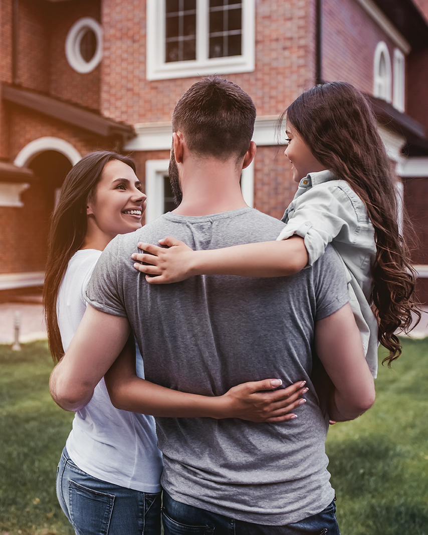 Happy family of three in front of their new house in South Carolina after a home inspection