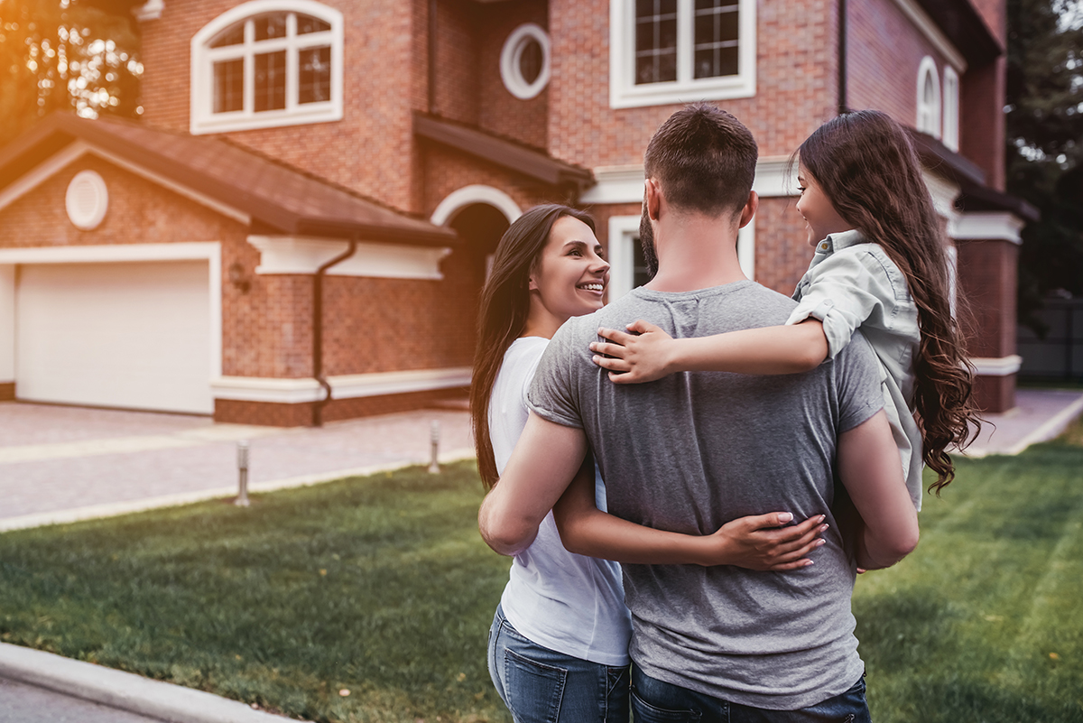 Happy family of three in front of their new house in North Carolina after a home inspection