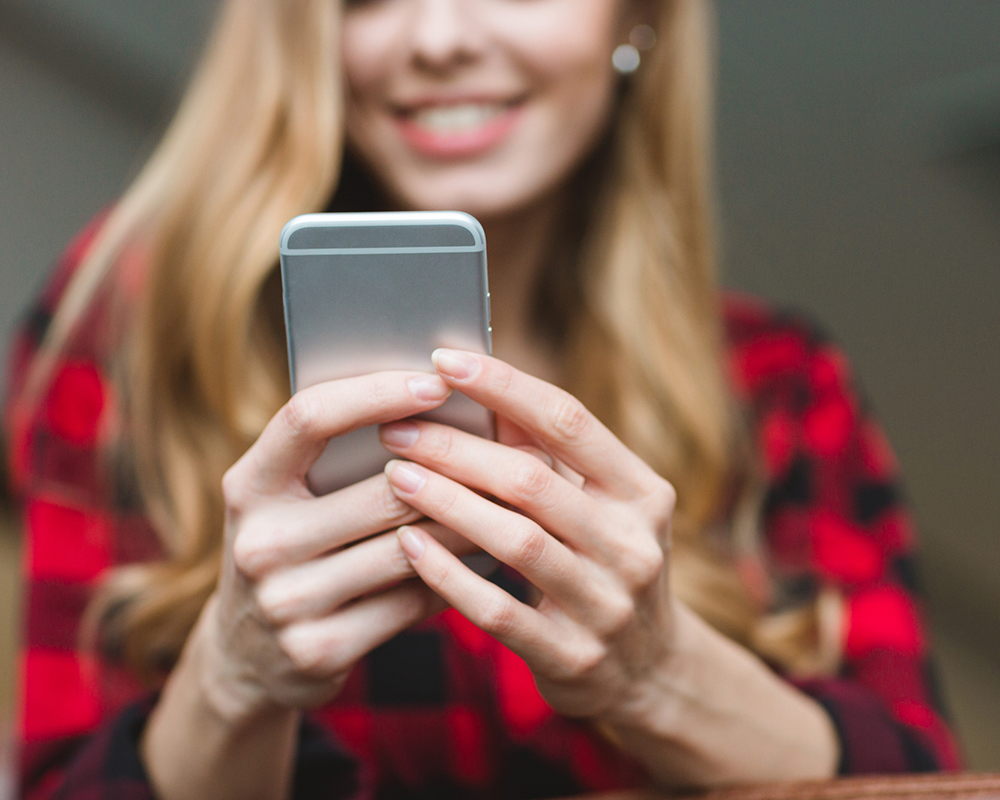 Woman using a smartphone to check her online digital home inspection report